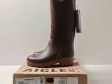 une photo d'une paire de bottes de pluie marron posées sur une boîte