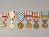 five medals and a cross on a white surface