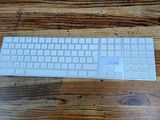 a white keyboard sitting on top of a wooden table