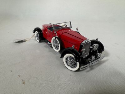 a red model of a car on a white surface