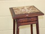 a small wooden table with a marble top on it