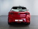 the back of a red car in a room with a white wall