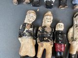 seven figurines of people standing together on a table