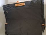 a black piece of luggage sitting on a white surface