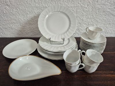 beaucoup d'assiettes et de tasses blanches sur une table