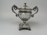 an antique silver plated sugar dish with a lid on a stand