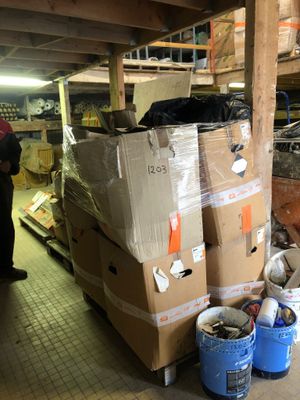 a man standing next to a pile of boxes in a warehouse