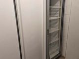 two refrigerators that are next to each other in a room