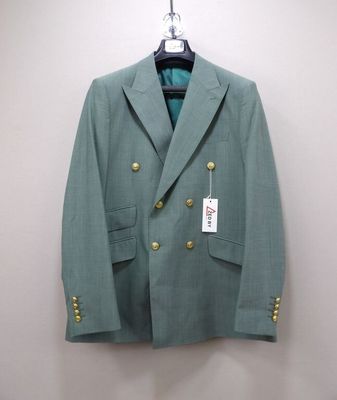 a green jacket hanging on a hanger on a wall