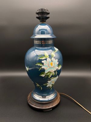 un vase bleu décoré de fleurs, posé sur une table