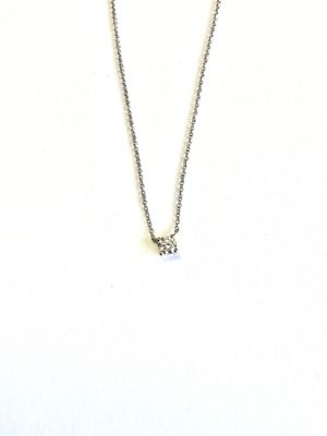 collier en argent orné d'un seul diamant sur une chaîne, sur fond blanc