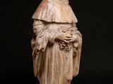 an old statue of a man holding a flower in his hands