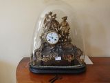 une horloge placée sous un dôme de verre sur une table