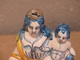 a figurine of a woman and a child sitting on a table