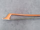 a close up of a wooden bow on a gray surface