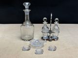 a glass decanter, a glass bowl, and other glass objects on a table