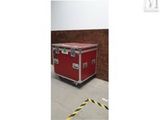une valise rouge posée sur un sol blanc