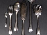 five forks and a spoon on a black table