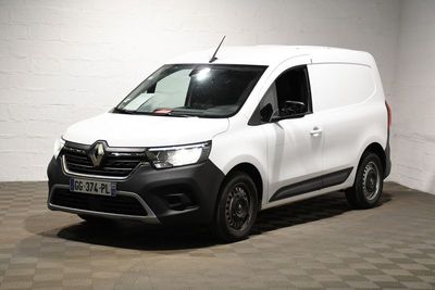 la camionnette blanche est garée dans une pièce au sol en damier