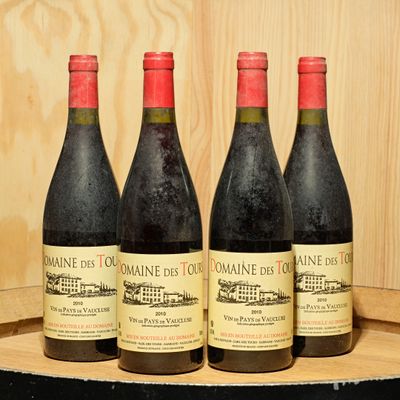 three bottles of wine sit on a wooden barrel in front of a wooden wall