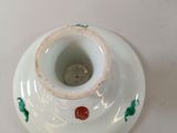 a small white vase with a red rose on it