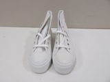 pair of white tennis shoes sitting on a white counter top