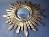 a gold starburst mirror on a blue cloth