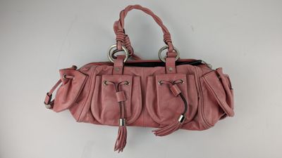 un gros plan sur un sac à main rose accroché au mur