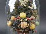 une cloche en verre contenant un bouquet de fruits