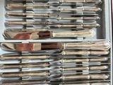 a lot of silverware in a box on a table