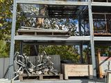 une cage à oiseaux avec un chat à l'intérieur, posée sur un tas de vieilleries
