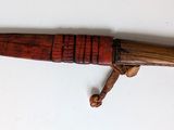 an old wooden pen with a wooden handle on a white surface