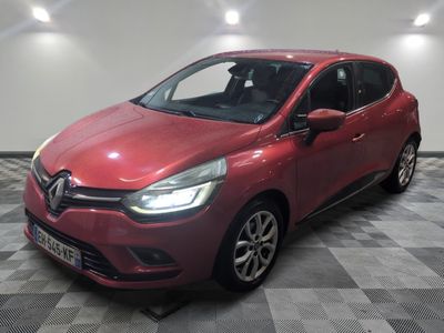 une voiture rouge garée dans un garage au sol en damier