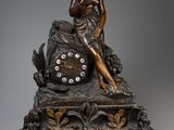 une image représentant une statue en bronze d'une femme assise sur une horloge