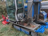 un tracteur qui est garé dans l'herbe près d'un bateau