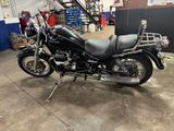 a black motorcycle parked in a garage next to stairs