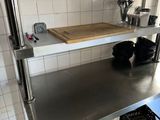 une étagère en acier inoxydable au milieu d'une cuisine