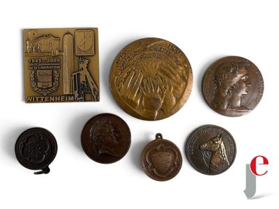 plusieurs types de pièces de monnaie et une médaille posées sur une surface blanche