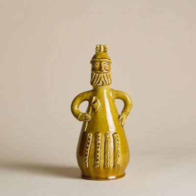 figurine en céramique jaune représentant un homme coiffé d'un chapeau