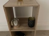 a small wooden shelf with a plant on top of it