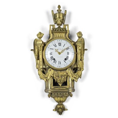 une horloge accrochée au mur et ornée d'anges