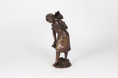 bronze statue of a woman with a basket on her head and a hat on her head