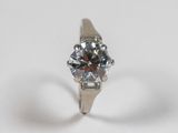 a close up of a diamond ring on a white surface