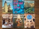 quatre livres posés sur une table en bois sur laquelle se trouve une horloge