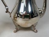 a silver tea pot sitting on a white table