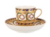 a close up of a cup and saucer on a white surface