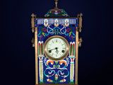 an ornate clock with a blue background and a white clock on top of it