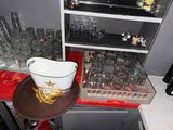a hat on top of a plate in front of a shelf of glasses