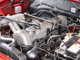 a red car engine with its hood open and the hood down