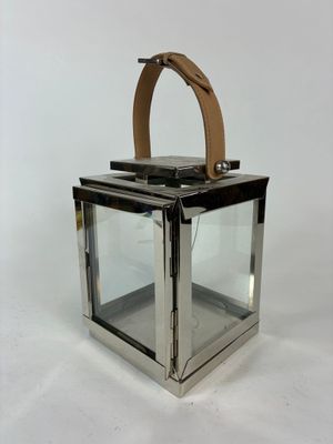une lanterne en verre avec une poignée en cuir sur fond blanc